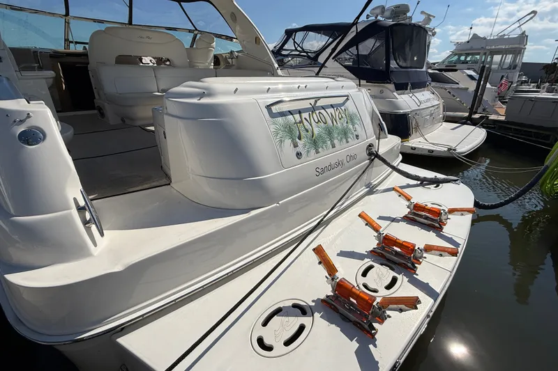 Slide: The Image of 2002 Sea Ray Sundancer 460 docked, featuring spacious deck and elegant interior seating. - 12