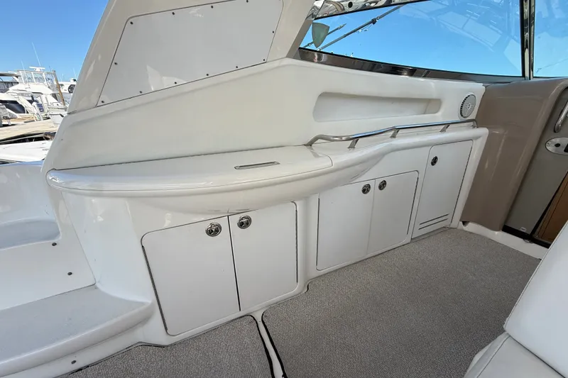 Slide: The Image of Interior view of a 2002 Sea Ray Sundancer 460 yacht, featuring white cabinetry and seating. - 21