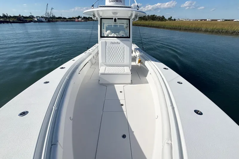 Slide: The Image of 2026 Onslow Bay 33 Tournament Edition boat on calm water, showcasing spacious deck and sleek design. - 13