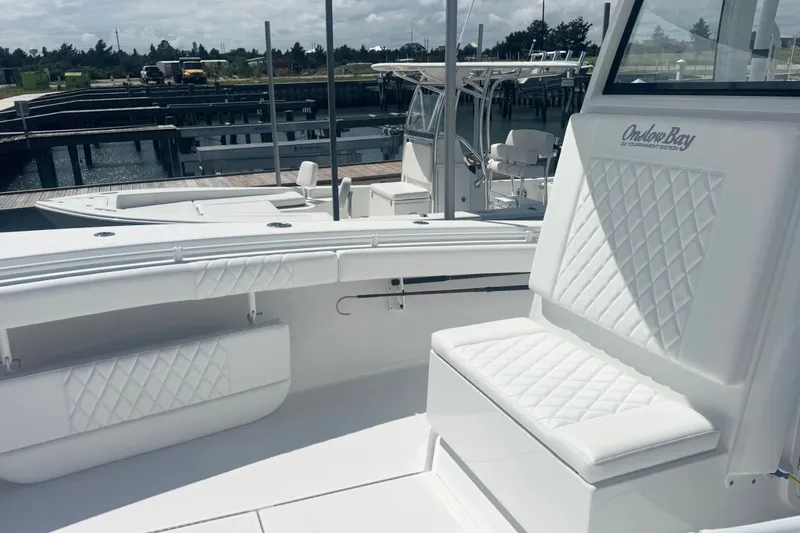 Slide: The Image of 2026 Onslow Bay 33 Tournament Edition boat with white quilted seating at a marina. - 17