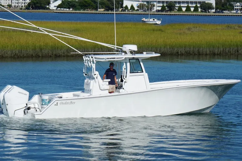 Slide: The Image of 2026 Onslow Bay 33 Tournament Edition boat cruising on a serene waterway. - 1