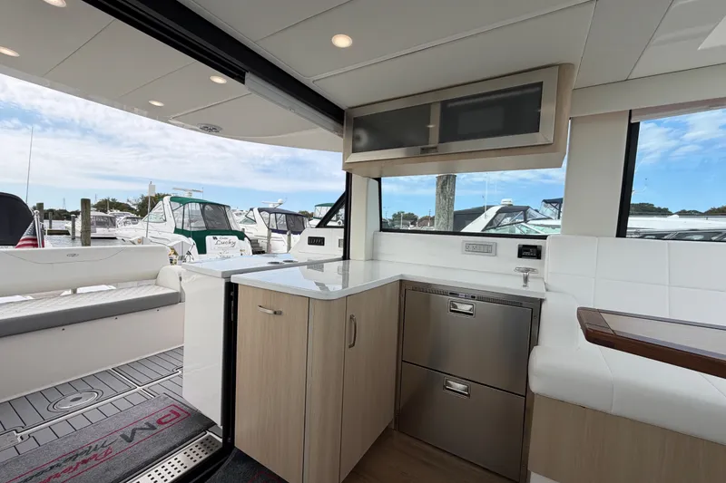 Slide: The Image of Modern interior of 2023 Regal 38 XO yacht with sleek cabinetry and marina view. - 11