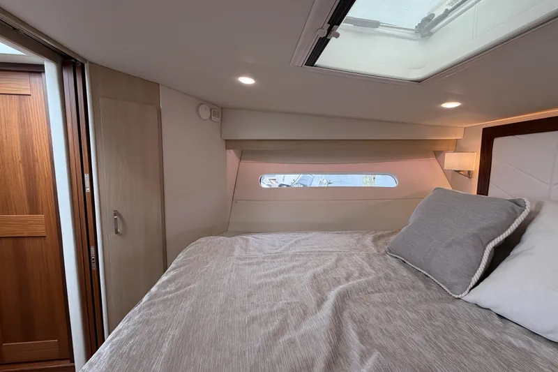 Slide: The Image of Luxurious cabin interior of 2023 Regal 38 XO yacht with skylight and cozy bedding. - 22