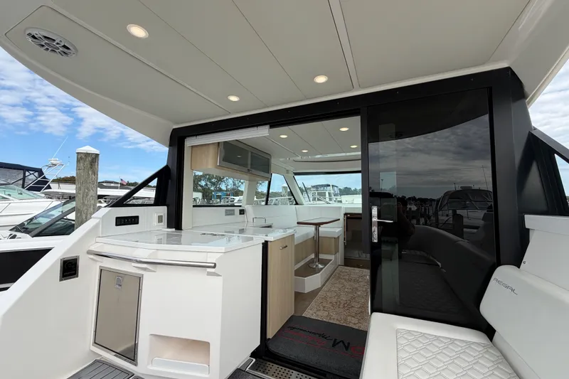 Slide: The Image of 2023 Regal 38 XO yacht interior with modern kitchen and seating area. - 7