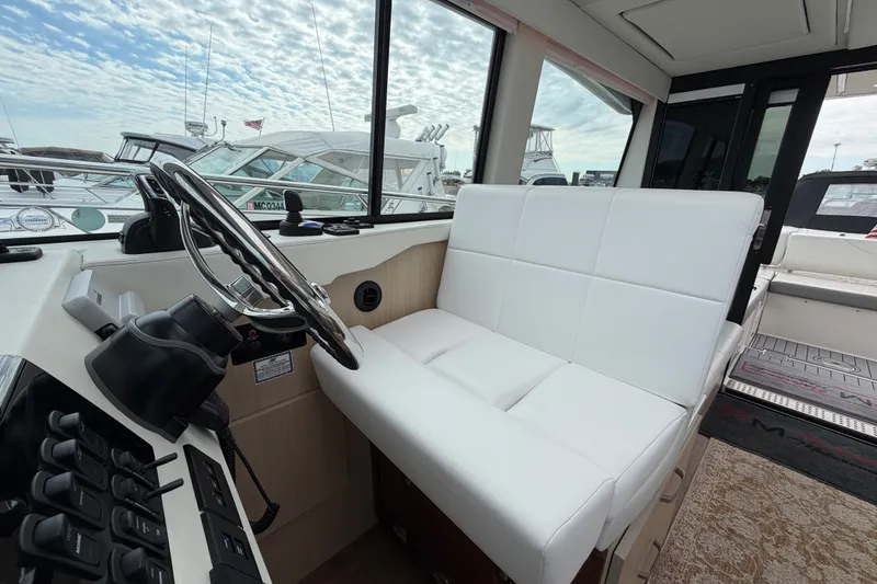 Slide: The Image of Interior of 2023 Regal 38 XO yacht with white seating and modern helm controls. - 15