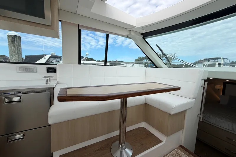 Slide: The Image of Interior of 2023 Regal 38 XO yacht with white seating and wooden table. - 13