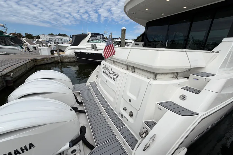 Slide: The Image of 2023 Regal 38 XO yacht docked, featuring triple Yamaha engines and sleek design. - 4