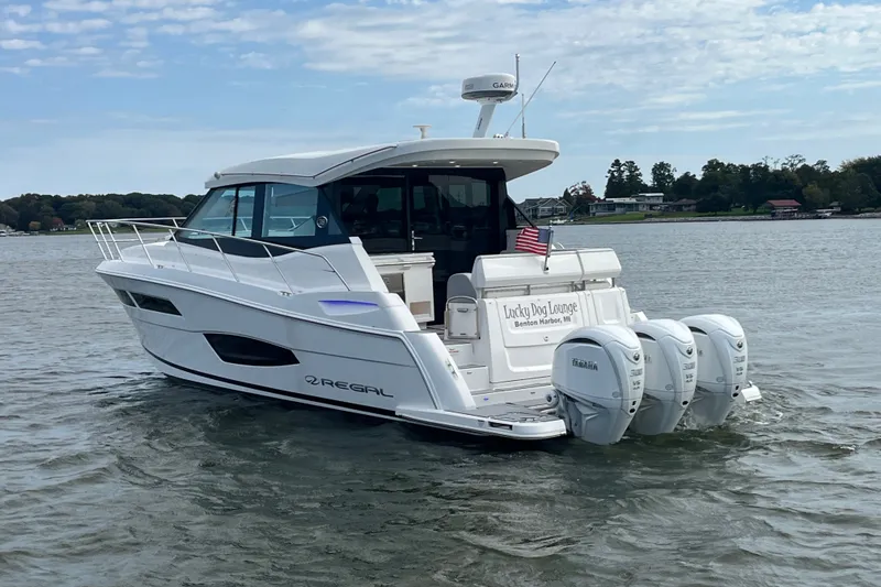 Slide: The Image of 2023 Regal 38 XO yacht cruising on a lake with triple Yamaha engines. - 34