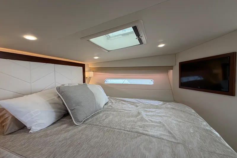 Slide: The Image of Luxurious cabin interior of 2023 Regal 38 XO yacht with skylight and TV. - 21