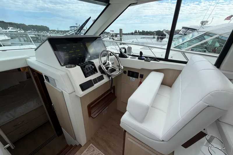 Slide: The Image of 2023 Regal 38 XO yacht helm with modern controls and white seating. - 14