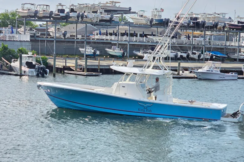 Slide: The Image of 2016 Regulator 41 boat named "King Fish" cruising in a marina with docked boats. - 4