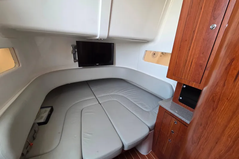 Slide: The Image of 2016 Regulator 41 cabin interior with TV, gray seating, and wooden cabinetry. - 12