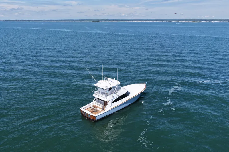 Slide: The Image of A 2027 Viking 58 Convertible cruising on calm waters with a clear sky in the background. - 9