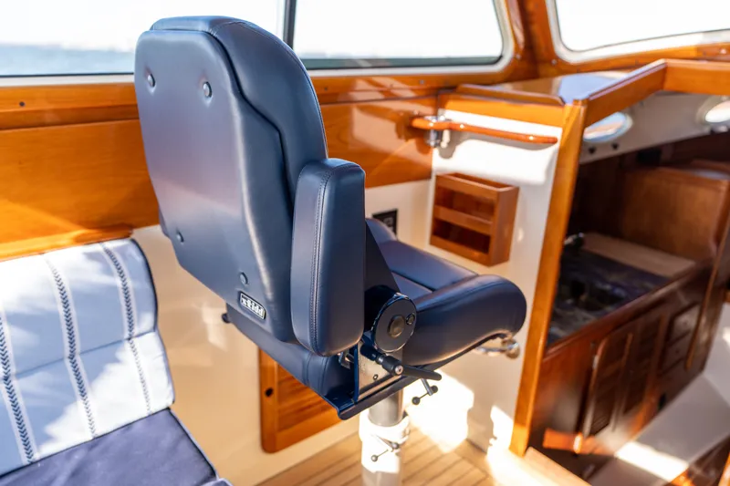Slide: The Image of Captain's chair in 2006 Hinckley Picnic Boat 36 EP, featuring elegant wood interior. - 33