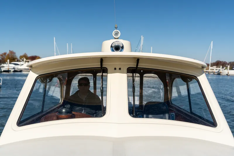 Slide: The Image of 2006 Hinckley Picnic Boat 36 EP cruising on a sunny day, with a person at the helm. - 18