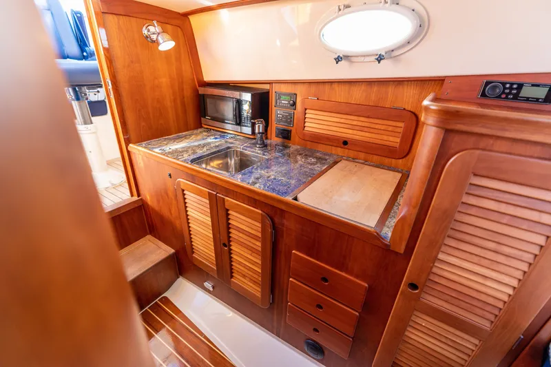 Slide: The Image of Hinckley Picnic Boat 36 EP 2006 galley with wood cabinetry, sink, and microwave. - 42