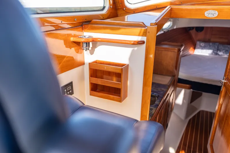 Slide: The Image of Interior of 2006 Hinckley Picnic Boat 36 EP, featuring wood accents and cozy cabin space. - 34