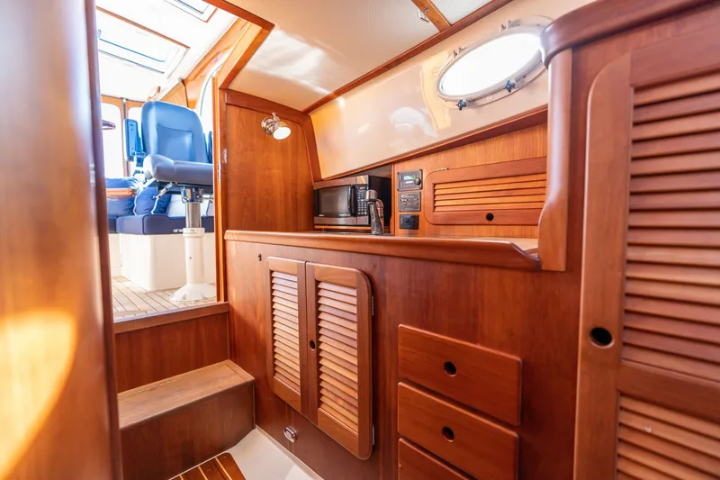 Slide: The Image of Interior of 2006 Hinckley Picnic Boat 36 EP with wooden cabinetry and blue seating. - 41