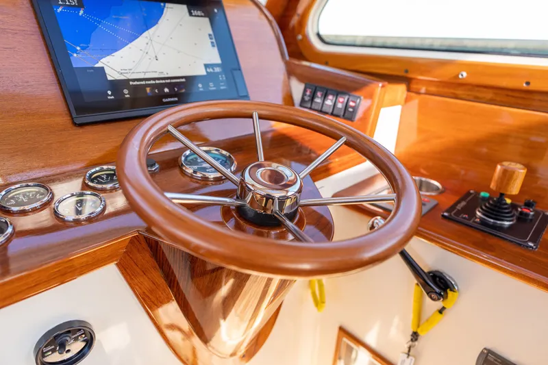 Slide: The Image of Helm of 2006 Hinckley Picnic Boat 36 EP with wooden steering wheel and navigation display. - 38