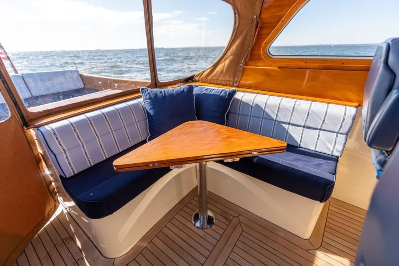 Slide: The Image of Interior of 2006 Hinckley Picnic Boat 36 EP with cozy seating and wooden table. - 28
