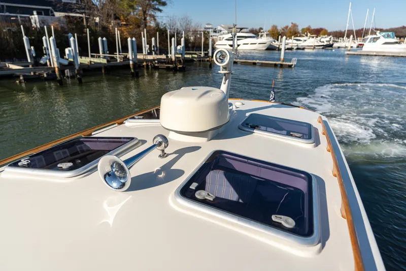 Slide: The Image of 2006 Hinckley Picnic Boat 36 EP cruising in a marina, showcasing deck details and hatches. - 17