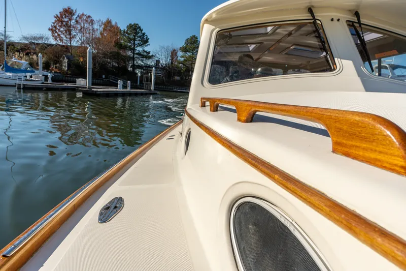 Slide: The Image of 2006 Hinckley Picnic Boat 36 EP docked, showcasing elegant wooden railings and sleek design. - 16