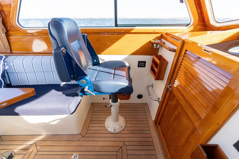 Slide: The Image of Interior of 2006 Hinckley Picnic Boat 36 EP with blue seating and wooden finishes. - 29