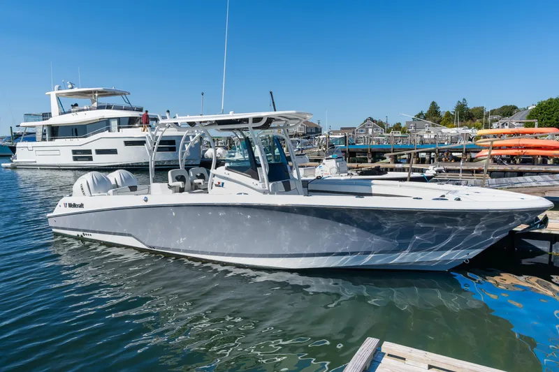 The Image of 2024 Wellcraft 302 Fisherman boat docked in marina, clear blue sky. - 0