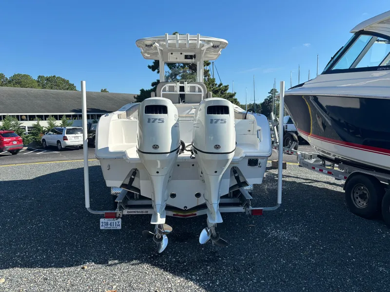 Slide: The Image of A 2021 Sea Pro 259 DLX with twin 175 HP engines, parked on a gravel lot. - 5