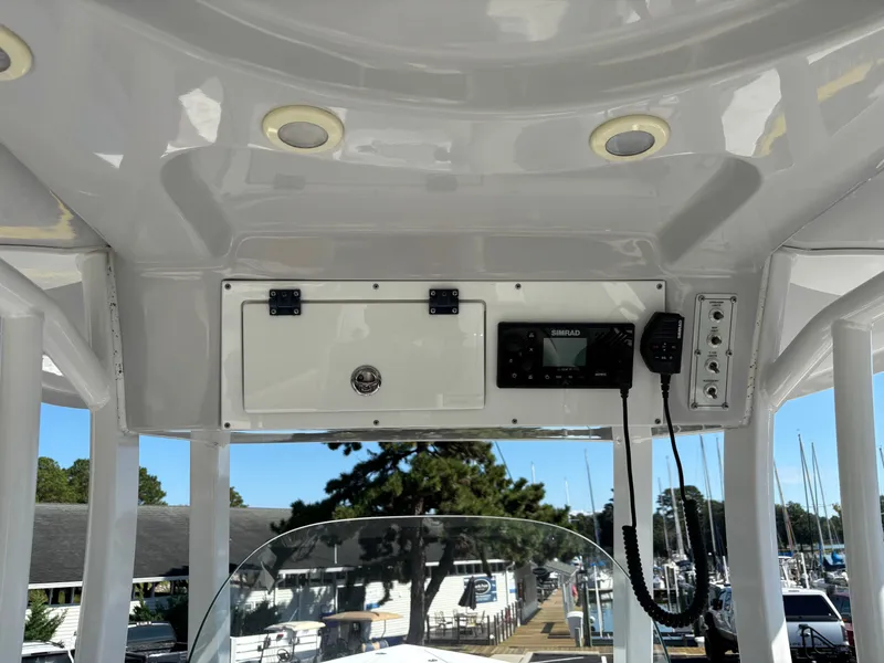 Slide: The Image of The image shows the helm of a 2021 Sea Pro 259 DLX boat with electronics and storage. - 14