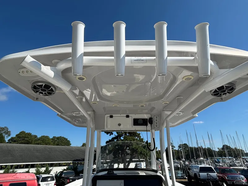 Slide: The Image of The image shows the T-top of a 2021 Sea Pro 259 DLX boat with rod holders and speakers. - 15