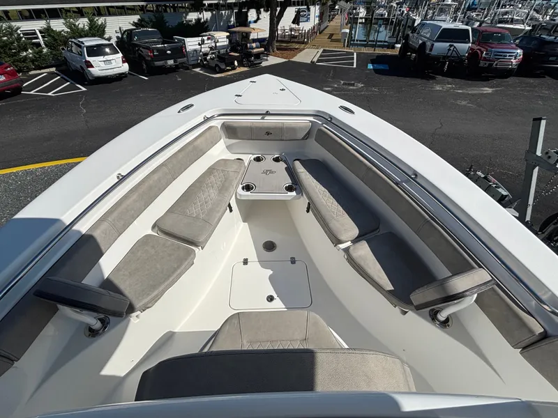 Slide: The Image of The image shows the bow of a 2021 Sea Pro 259 DLX boat with gray cushions and cup holders. - 8