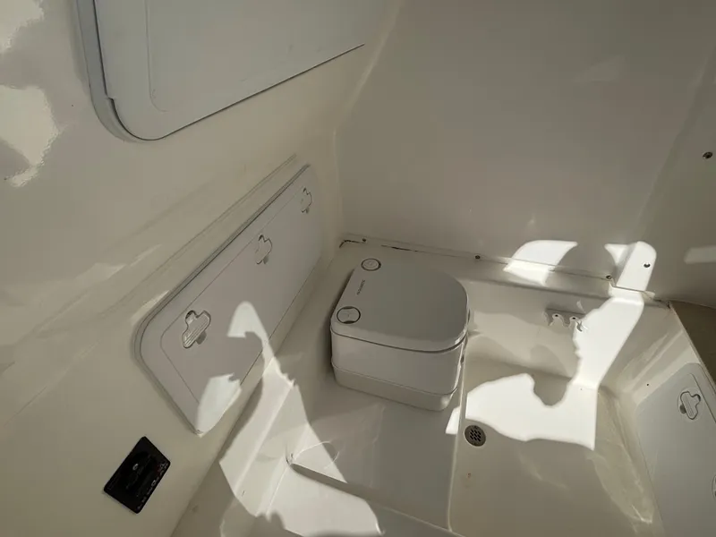 Slide: The Image of Interior view of a boat with a portable toilet and storage compartment. - 10