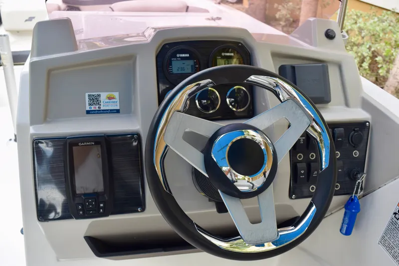 Slide: The Image of 2024 Starcraft SVX 231 OB DH boat dashboard with steering wheel and Garmin display. - 8