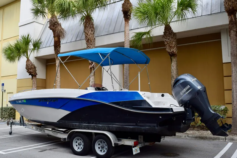 Slide: The Image of 2024 Starcraft SVX 231 OB DH boat with Yamaha engine on trailer, parked near palm trees. - 4