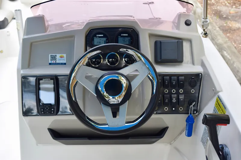Slide: The Image of 2024 Starcraft SVX 231 OB DH boat dashboard with steering wheel and control panel. - 7