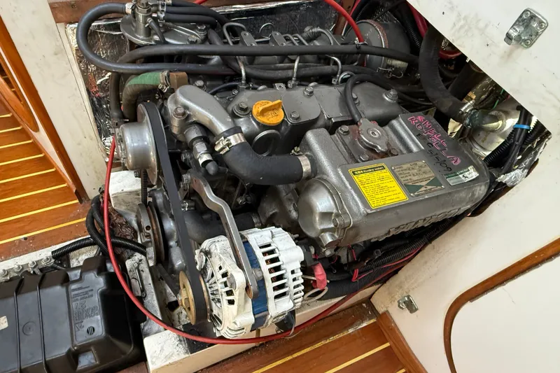 Slide: The Image of Engine compartment of a 1994 J Boats J/120 sailboat, showcasing detailed mechanical components. - 77