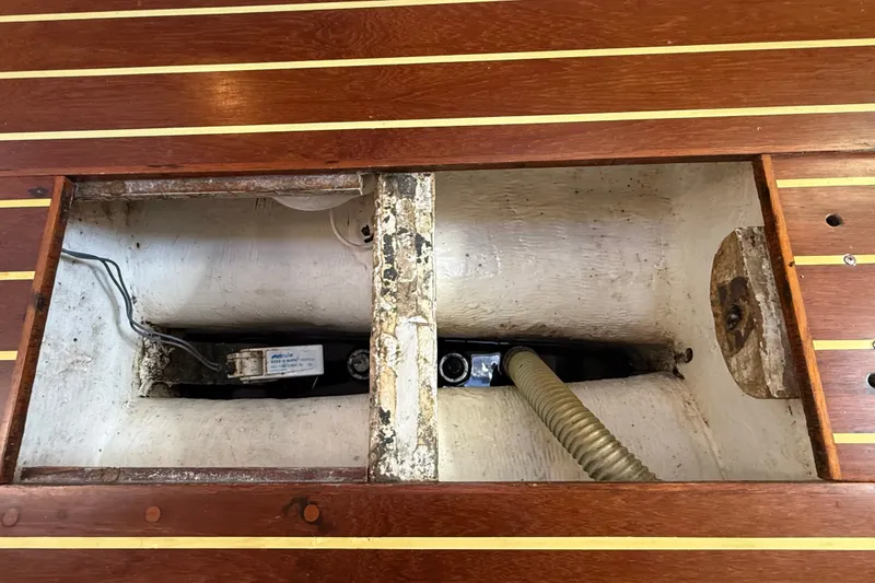 Slide: The Image of Bilge compartment of a 1994 J Boats J/120, featuring wooden flooring and visible wiring. - 85