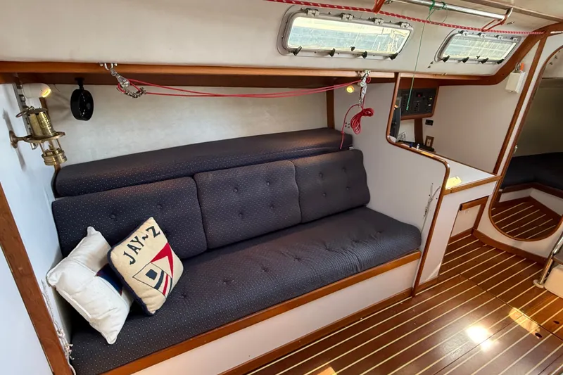 Slide: The Image of Cozy interior of 1994 J Boats J/120 sailboat with cushioned seating and nautical decor. - 16