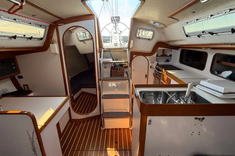 Slide: The Image of Interior of a 1994 J Boats J/120 sailboat, featuring a compact kitchen and cozy cabin space. - 17