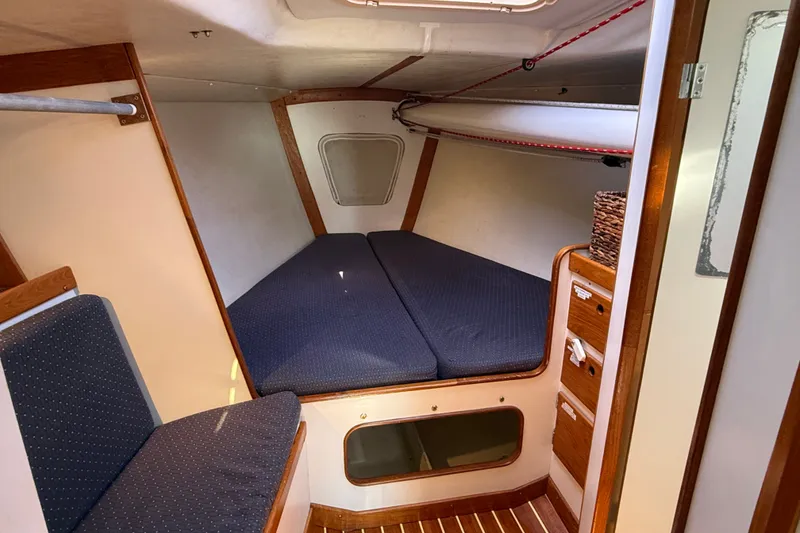Slide: The Image of 1994 J Boats J/120 cabin interior with blue cushions and wooden accents. - 39