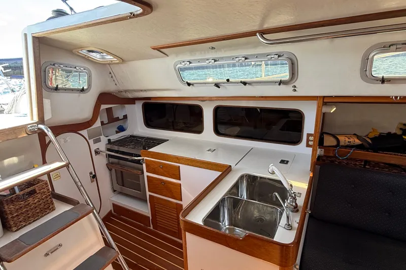 Slide: The Image of Interior of a 1994 J Boats J/120 sailboat, featuring a compact kitchen area. - 21