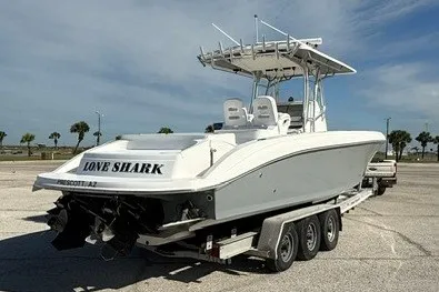 Slide: The Image of 2009 Spectre 37 boat on trailer, named "Love Shark," parked in sunny lot. - 3