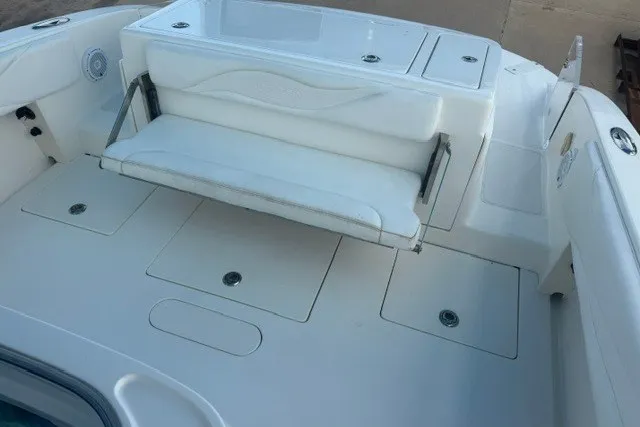Slide: The Image of White seating area on a 2009 Spectre 37 boat deck, featuring storage compartments. - 16