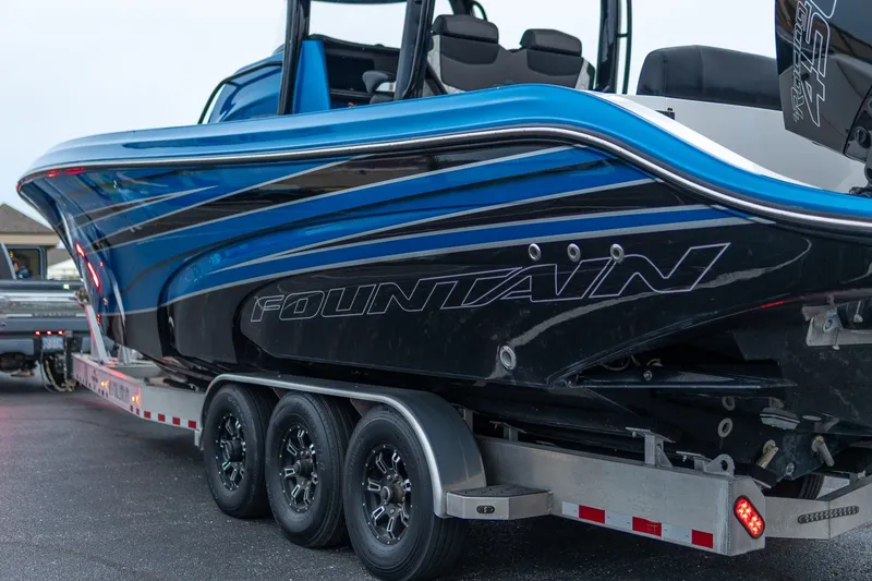 Slide: The Image of 2022 Fountain 39 NX boat on trailer, showcasing sleek blue and black design. - 9