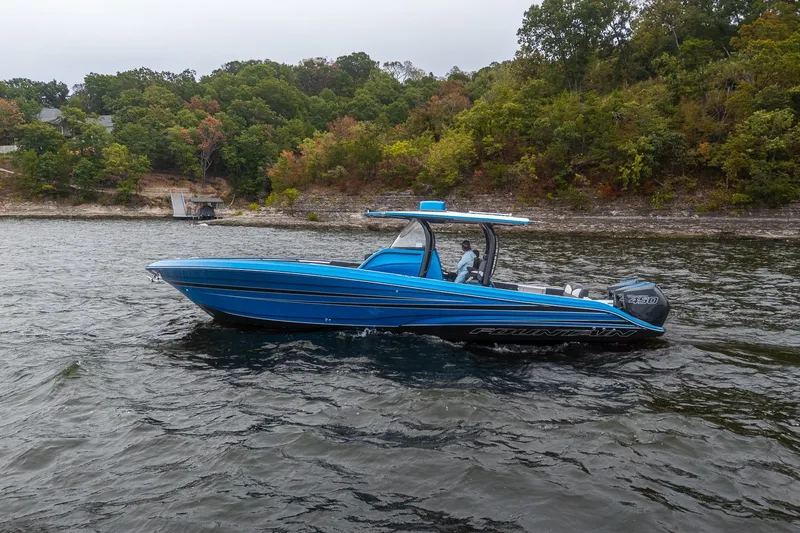 Slide: The Image of 2022 Fountain 39 NX boat cruising on a lake with lush green shoreline. - 4