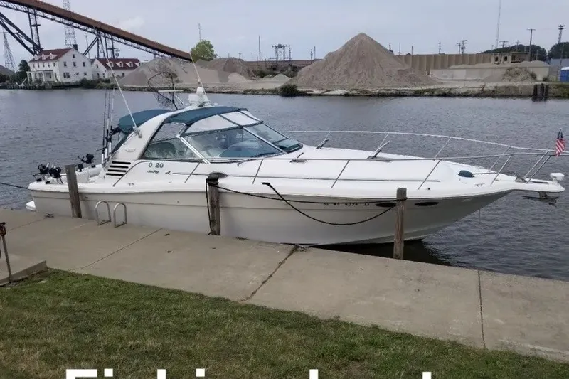 Slide: The Image of 1998 Sea Ray 370 Express Cruiser docked by a riverside with industrial backdrop. - 6