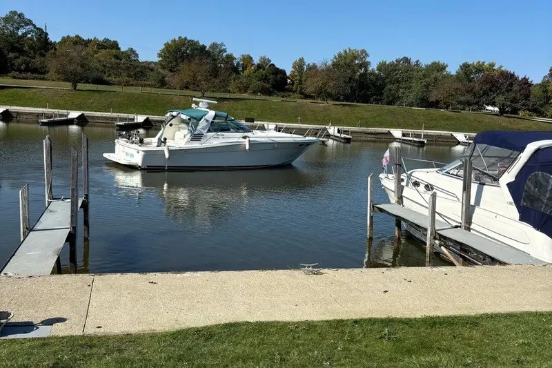 Slide: The Image of 1998 Sea Ray 370 Express Cruiser docked in a serene marina setting. - 12