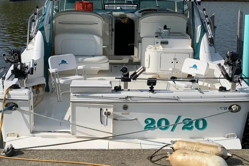 Slide: The Image of 1998 Sea Ray 370 Express Cruiser docked, featuring spacious seating and fishing equipment. - 8