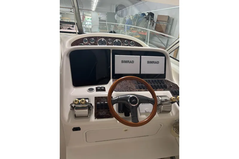 Slide: The Image of 1998 Sea Ray 370 Express Cruiser helm with Simrad displays and wooden steering wheel. - 7